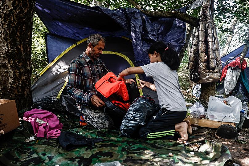 alah, imigrant z Iraku i jego córka Arwa, lat 10, przygotowują kamizelki ratunkowe w prowizorycznym obozie dla migrantów w Dunkierce w północnej Francji SAMEER AL-DOUMY / AFP